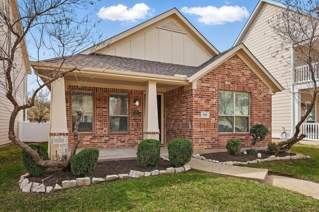 924 Charleston Ln, Savannah, TX 76227 - view of front facade with brick siding, board and batten siding, a shingled roof, and covered porch