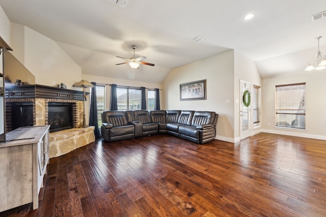 living area featuring lofted ceiling, hardwood / wood-style flooring, visible vents, and ceiling fan with notable chandelier