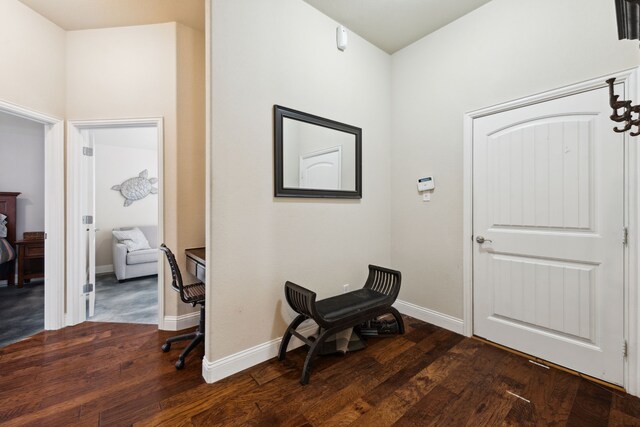 foyer entrance with baseboards and dark wood-style floors