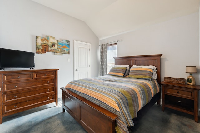 bedroom featuring lofted ceiling and dark colored carpet