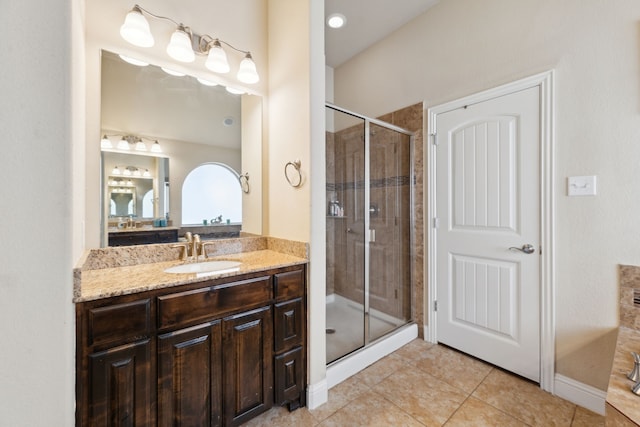 bathroom with a shower stall, tile patterned flooring, and vanity