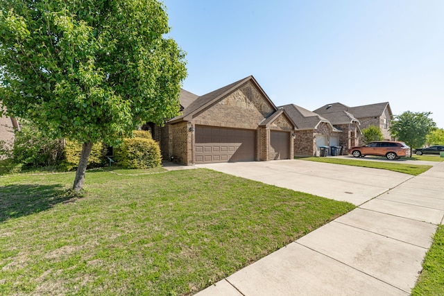view of front of house with an attached garage, brick siding, driveway, and a front lawn