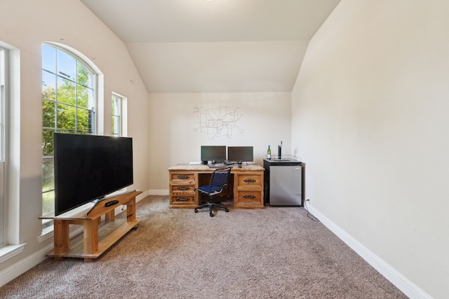 office space featuring light colored carpet, lofted ceiling, and baseboards