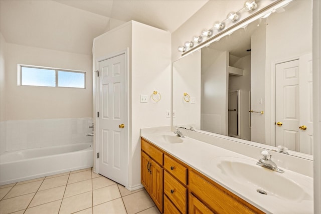 full bathroom featuring a sink, a bath, tile patterned flooring, and double vanity