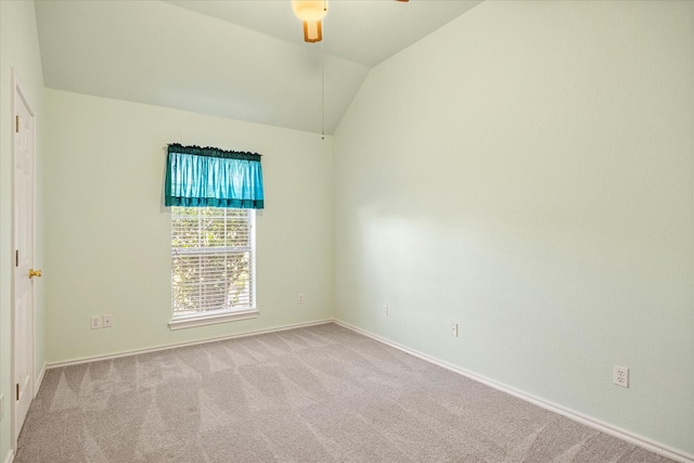 carpeted spare room featuring baseboards, a ceiling fan, and lofted ceiling