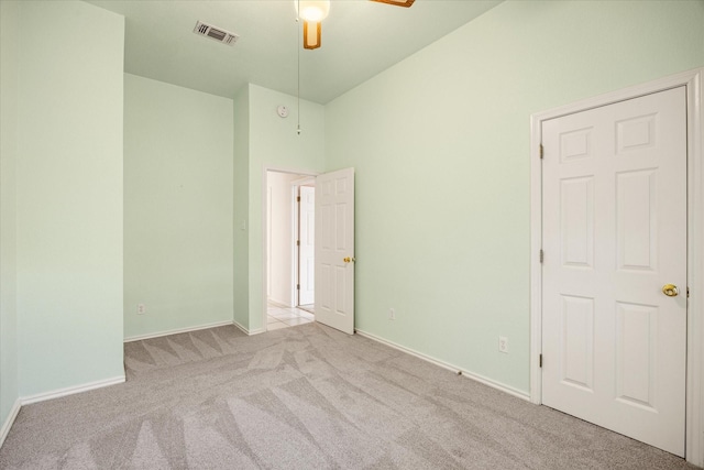 interior space featuring carpet flooring, a ceiling fan, baseboards, and visible vents