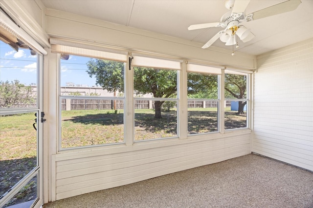 unfurnished sunroom featuring a ceiling fan