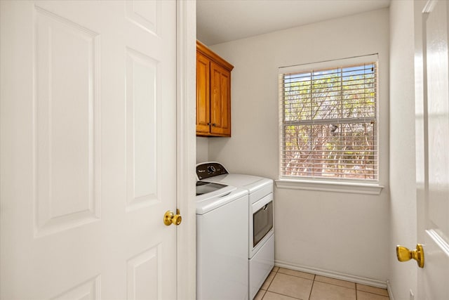 laundry room with light tile patterned floors, baseboards, cabinet space, and washer and dryer