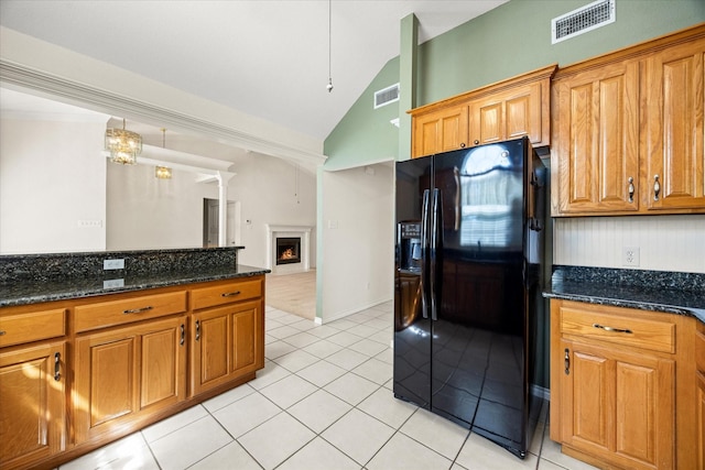 kitchen with black fridge with ice dispenser, brown cabinets, and visible vents