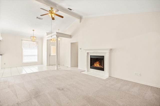 unfurnished living room with a ceiling fan, visible vents, beam ceiling, and a tile fireplace