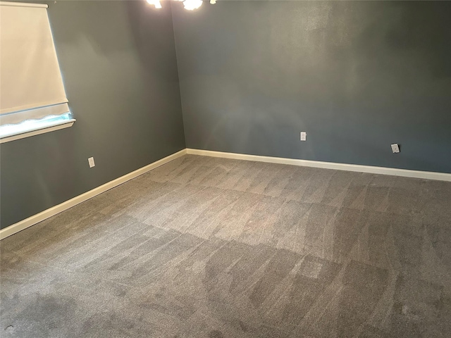 empty room with baseboards and carpet