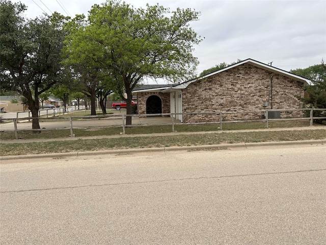 view of front of property with concrete driveway, an attached garage, brick siding, and fence private yard