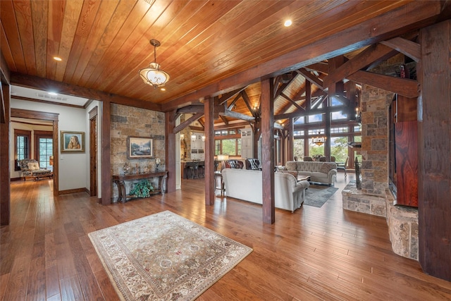 interior space featuring a stone fireplace, a healthy amount of sunlight, wood ceiling, and hardwood / wood-style floors