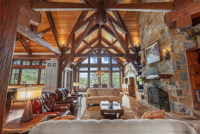 living area with a towering ceiling, wood finished floors, wooden ceiling, beamed ceiling, and a fireplace