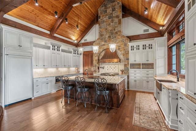 kitchen with high vaulted ceiling, wood ceiling, a sink, and built in appliances