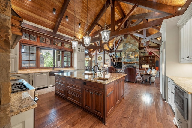 kitchen featuring open floor plan, wood ceiling, a fireplace, dark wood finished floors, and light stone countertops