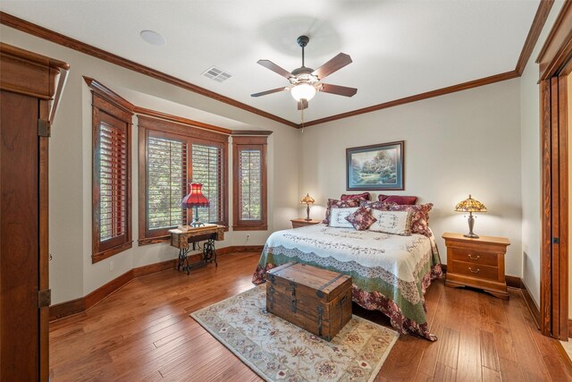 bedroom with hardwood / wood-style floors, visible vents, a ceiling fan, and baseboards