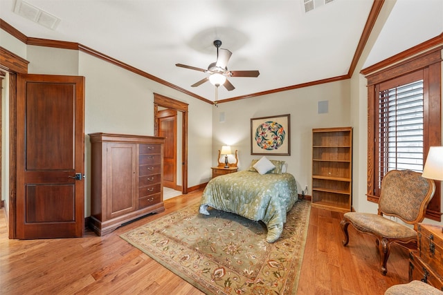 bedroom with ornamental molding, light wood finished floors, and visible vents