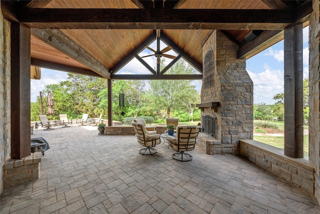 view of patio with an outdoor stone fireplace and a gazebo