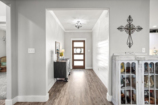 entrance foyer with crown molding, baseboards, and wood finished floors