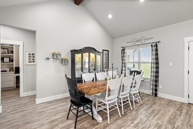 dining room featuring beam ceiling, light wood-style floors, high vaulted ceiling, recessed lighting, and baseboards