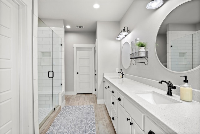 full bath featuring visible vents, a sink, recessed lighting, and a shower stall