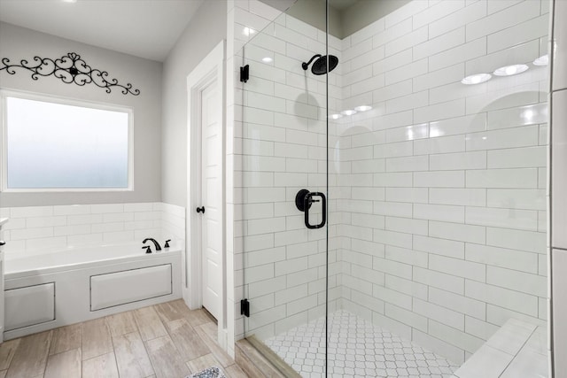 bathroom featuring a shower stall and a garden tub