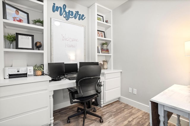 office with baseboards, wood finished floors, and built in study area