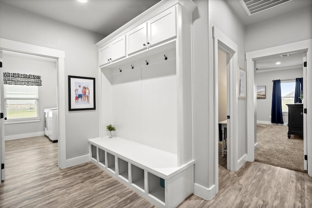 mudroom featuring baseboards, visible vents, plenty of natural light, and light wood finished floors
