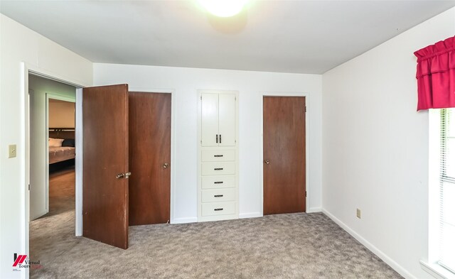 9820 Hillsboro Dr, Shreveport, LA 71118 - unfurnished bedroom featuring carpet floors, baseboards, and two closets