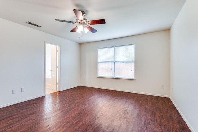 spare room with baseboards, a ceiling fan, wood finished floors, and visible vents