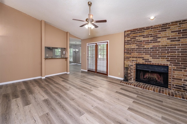 1201 Harwell Dr Unit 225, Arlington, TX 76011 - unfurnished living room featuring ceiling fan, a fireplace, a textured ceiling, baseboards, and vaulted ceiling