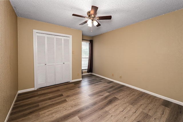 1201 Harwell Dr Unit 225, Arlington, TX 76011 - unfurnished bedroom featuring dark wood-style floors, a textured ceiling, a closet, and baseboards