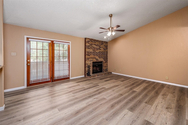 1201 Harwell Dr Unit 225, Arlington, TX 76011 - unfurnished living room featuring ceiling fan, wood finished floors, a textured ceiling, baseboards, and a fireplace
