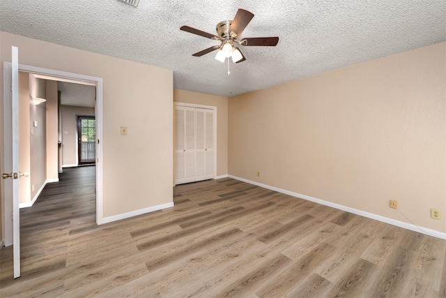 1201 Harwell Dr Unit 225, Arlington, TX 76011 - unfurnished bedroom featuring wood finished floors, baseboards, a textured ceiling, a closet, and a ceiling fan
