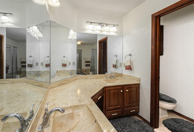 1201 Harwell Dr Unit 225, Arlington, TX 76011 - bathroom with a textured ceiling, double vanity, and toilet