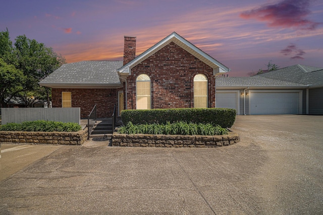 6127 Welden Ct, Fort Worth, TX 76132 - view of front facade featuring a chimney, an attached garage, brick siding, and driveway