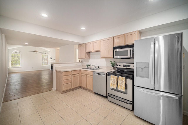 6127 Welden Ct, Fort Worth, TX 76132 - kitchen with light countertops, light brown cabinets, a sink, appliances with stainless steel finishes, and open floor plan
