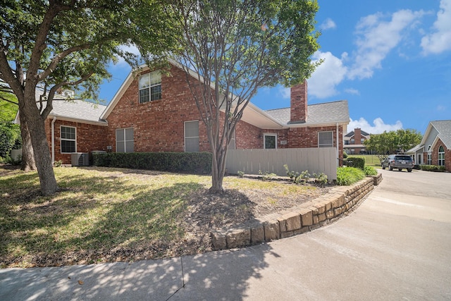 6127 Welden Ct, Fort Worth, TX 76132 - view of front of property featuring a chimney, fence, central AC, concrete driveway, and brick siding