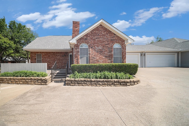 6127 Welden Ct, Fort Worth, TX 76132 - view of front of property with concrete driveway, a chimney, fence, a garage, and brick siding
