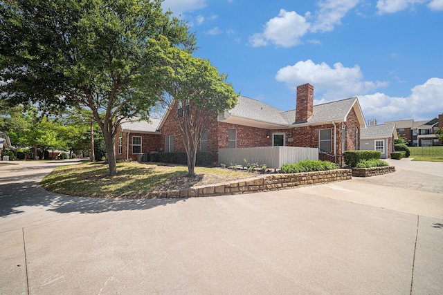 6127 Welden Ct, Fort Worth, TX 76132 - view of property exterior with brick siding, a chimney, and fence