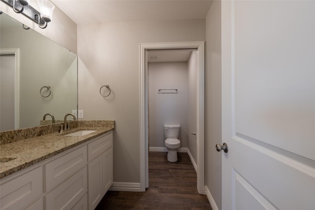 2567 Fm 368, Iowa Park, TX 76367 - bathroom with baseboards, wood finished floors, vanity, and toilet