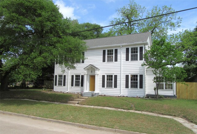 415 Easy St, Marlin, TX 76661 - colonial inspired home featuring fence, roof with shingles, and a front yard