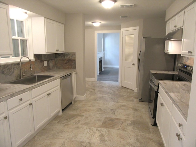 415 Easy St, Marlin, TX 76661 - kitchen featuring a sink, decorative backsplash, stainless steel appliances, under cabinet range hood, and visible vents