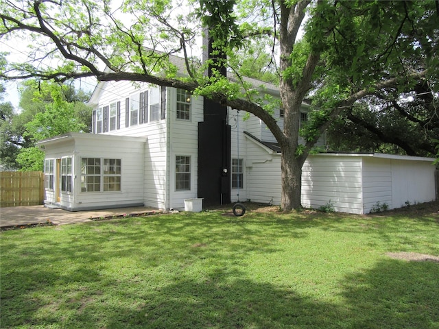 415 Easy St, Marlin, TX 76661 - back of house featuring fence, a lawn, a chimney, and a patio