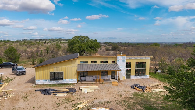rear view of house featuring metal roof