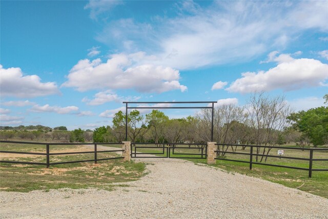 view of road featuring a rural view and a gate