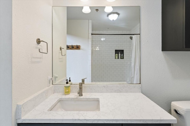 full bathroom with a shower with shower curtain, a textured wall, toilet, and vanity