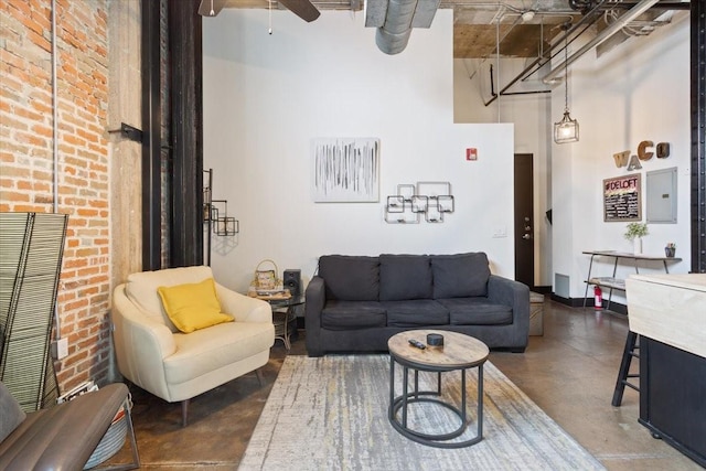 living room featuring concrete flooring, electric panel, a towering ceiling, and a ceiling fan