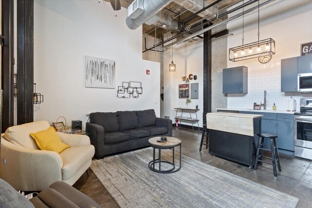 living room featuring concrete floors and a high ceiling